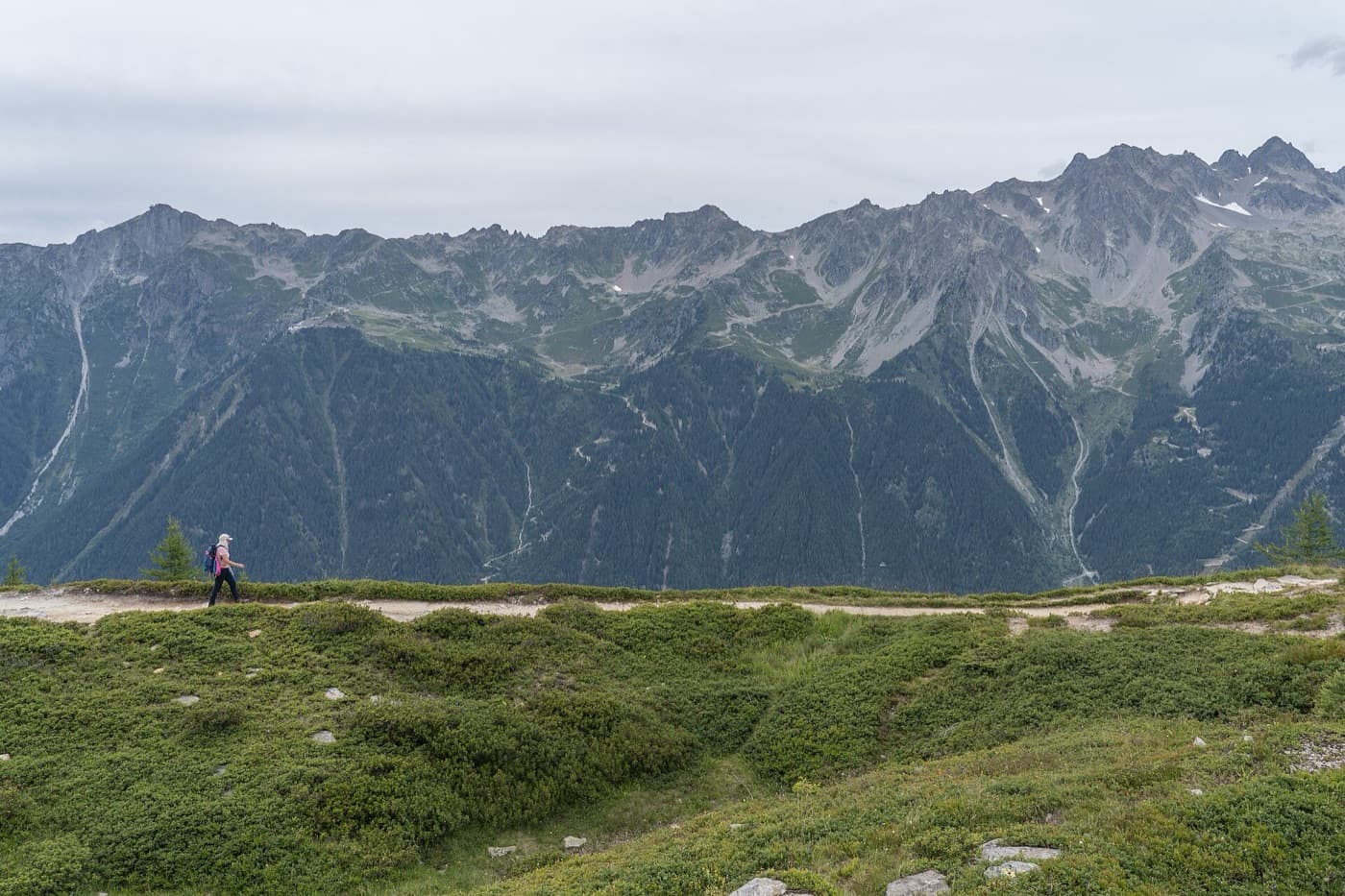 Randonneuse évoluant sur le sentier du Grand Balcon Nord, face aux sommets de la vallée de Chamonix